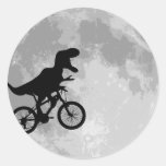 Dinossauro em uma bicicleta no céu com lua adesivos em formato redondos