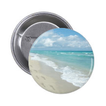 Pegadas no Sandy Beach branco, azul cénico do Aqua Boton