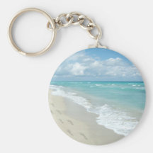 Pegadas no Sandy Beach branco, azul cénico do Aqua Chaveiro