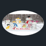 Adesivo Oval Vinhetas De Natal Bonitas De Snowman Com Nome De F<br><div class="desc">Bons Vinheiros de Natal do Snowman com o nome da família para os pacotes, cartões e presentes de Natal. Projetado com uma família de bonitinhos de neve vestidos para diversão de inverno, e seu nome familiar embaixo. Para personalizar, simplesmente insira seu texto em nosso modelo fácil, substituindo o exemplo. Aproveite!...</div>