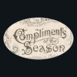 Adesivo Oval Vintage Compliors of Season Christmas Sticker<br><div class="desc">A tipografia da colheita de excelentes com espirais e cartazes que soletra os Cumprimentos da Estação em uma etiqueta de antiguidade de creme suave faz um belo adesivo de férias.</div>