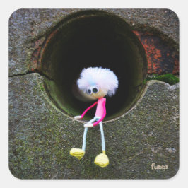 Adesivo Quadrado Fubby poppetje dat in een muur zit. 