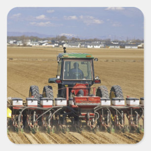 Adesivo Quadrado Trator puxando um plantador de milho-semente.