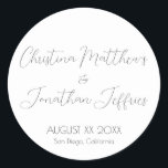 Adesivo Redondo Casamento Branco Moderno e Elegante<br><div class="desc">Este moderno e elegante evento ou adesivo de casamento apresenta um simples fundo branco com texto preto. Os nomes do casal são impressos em uma fonte de script. A data e o local do casamento são impressos abaixo.</div>