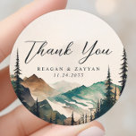 Adesivo Redondo Casamento De Pinheiros Das Montanhas Watercolor Ob<br><div class="desc">Conte sua gratidão com a beleza tranquila do Casamento de Pinheiros das Montanhas Watercolor, Obrigado Clássico Round Sticker. Este adesivo, impresso em material durável, apresenta uma cena serena de aquarela de montanhas e uma floresta de pinheiros. Uma mensagem sincera de "Obrigado", escrita na tipografia moderna, aprecia o centro do autocolante....</div>