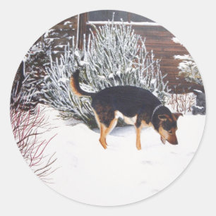 Adesivo Redondo Cena da neve do inverno com o cão preto e tan