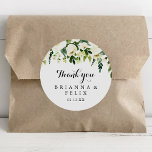 Adesivo Redondo Greenery White Floral Obrigado Favor De Casamento<br><div class="desc">Este obrigado floral branco verde que o teu casamento a favor de um adesivo redondo clássico é perfeito para um casamento rústico. O design apresenta elegantes pedras brancas de aquarela com folhagem verde. Faça com que a etiqueta do adesivo seja sua, incluindo seus nomes, o evento (se aplicável) e a...</div>