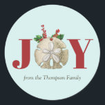 Adesivo Redondo Joy Christmas Sand Dollar Holly Berries Coastal<br><div class="desc">Um design de Natal de Joy,  do templo litoral,  com um dólar de areia,  enquadrado com o santo de Natal e as bagas num fundo de turquesa leve. Design festivo perfeito para o Natal.</div>