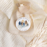 Adesivo Redondo Monograma de Árvores Aquarela da Montanha Rústica<br><div class="desc">Nossa coleção "Montanha Rústica" apresenta paisagens em aquarela combinadas com itens decorativos de fatias de madeira, criando um visual sofisticado inspirado na natureza. A paleta de cores consiste em marrons e azuis suaves com um toque de verde. Todas as informações estão em uma combinação de fonte script e serifa. Verifique...</div>