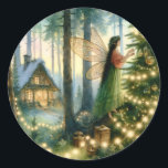 Adesivo Redondo Natal do Cottage Core Whimsic<br><div class="desc">Ilustração de arte química de uma fada ou anjo decorando uma árvore de Natal com luzes brancas iluminadas com uma linda casota acolhedora no fundo.</div>