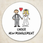 Adesivo Redondo Wedding Couple - Under New Management<br><div class="desc">A cute cartoon of a newlywed couple captioned 'under new management'. Is it the bride or groom that wears the trousers in the marriage? Great for a wedding gift,  or to wear on honeymoon.</div>