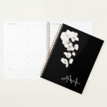 Agenda Monograma Floral das Orquídeas Negras e Brancas Mo<br><div class="desc">Descubra a elegância redefinida com nossos modernos Planadores de Monograma Floral das Orquídeas Negra e Branca. Abrace o apelo cômico e de moda de designs monocromáticos adornados com delicadas flores brancas e orquídeas brancas graciosas acima de um monograma chic de seu nome e inicial. Cada planejador exude sofisticação, seja personalizado...</div>