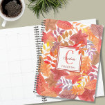 Agenda Nome Monograma Foliage<br><div class="desc">Este Planeador Colorido é decorado com um padrão de folhas de aquarela em rastos, amarelos e púrpuras. Facilmente personalizável com seu nome, monograma e ano. Use a opção Ferramenta Design para alterar o tamanho, o estilo e a cor do texto. Porque nós criamos a nossa trabalho de arte, você não...</div>