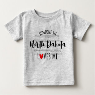 Alguém Na Dakota Do Norte Me Ama A Camisa Do Bebê