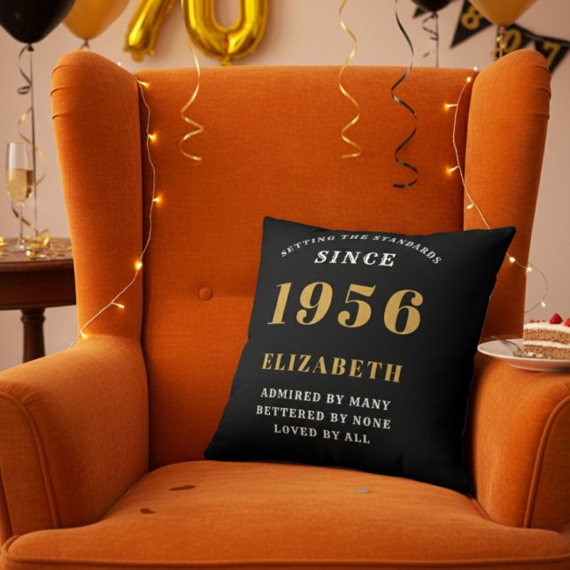 Almofada 70th Birthday Gift Personalized 1956 Black Gold (Personalized 70th birthday throw pillow on an orange velvet wingback chair)