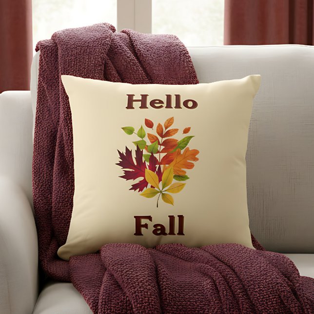 Almofada Olá Outono - Acento de Casa de Campo Rústico de Ou (“Hello Fall” pillow with colorful leaves and blanket creates a cozy autumn vibe.)