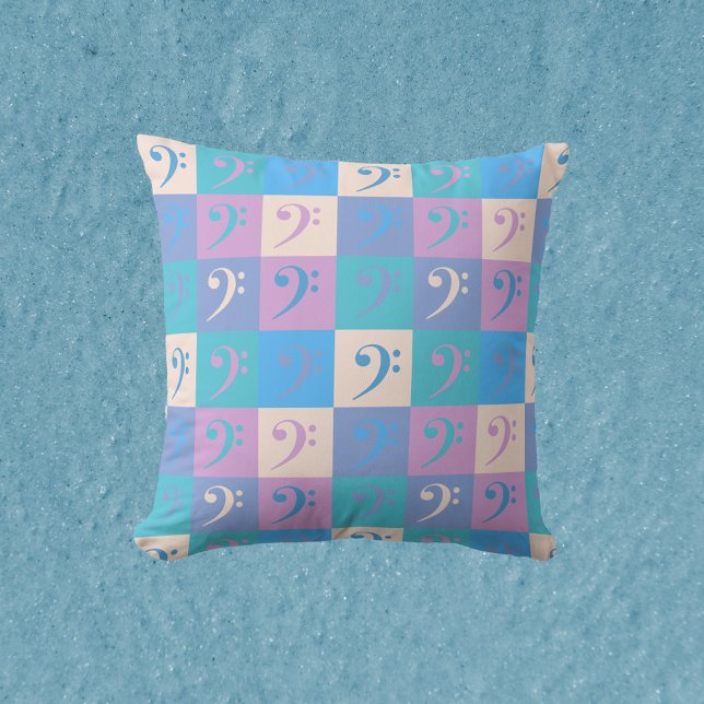 Almofada Padrão de Cores Pastel de Música emClave de Fá (A throw pillow with a pattern of bass clefs in a pastel color scheme.)