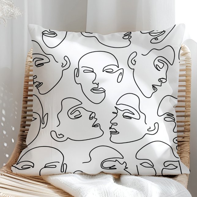 Almofada Rostos de Desenho de Linha Contemporânea (Contemporary Line Art Drawing Faces Throw Pillow on a sunny rattan armchair.)