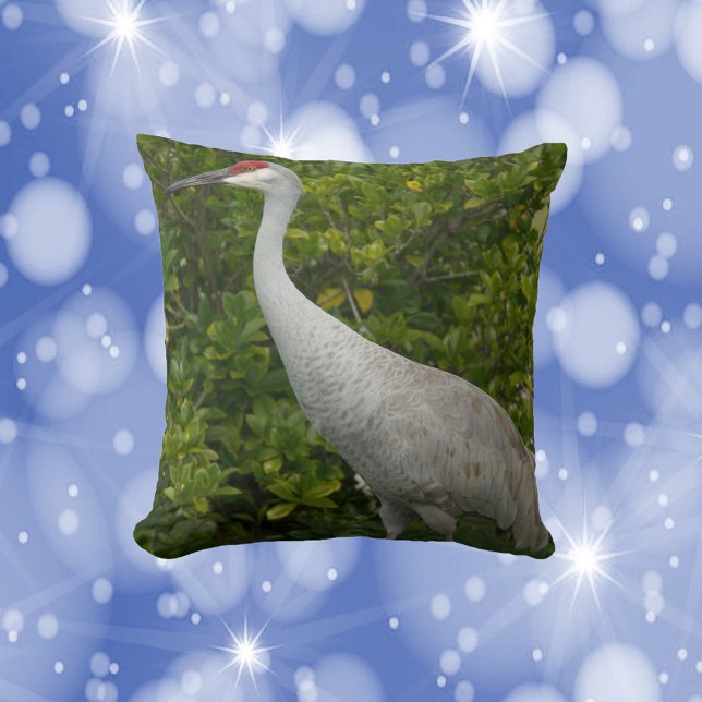 Almofada Sandhill Crane Bird em frente a Greenery Foto (A throw pillow featuring a photo of a sandhill crane bird.)