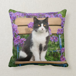 Almofada Tuxedo gato sentado numa cadeira de jardim com flo