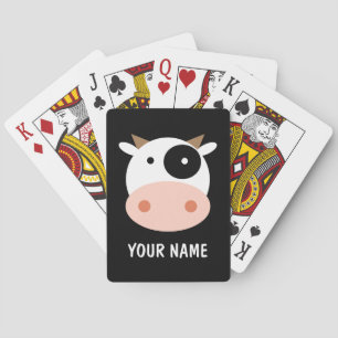 Baralho O miúdo joga cartas com um desenho de vaca fofo.