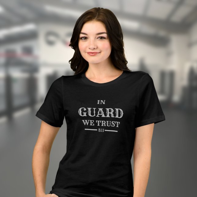 BJJ na Guarda Confiamos em Jiu Jitsu (Woman's Brazilian Jiu Jitsu T-shirt in black on a female model in a gym. )