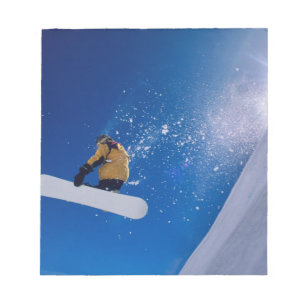 Bloco De Notas Homem voando pelo ar em uma snowboard com