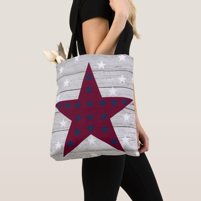 BOLSA TOTE AS ESTRELAS VERMELHAS E AZUIS NA MADEIRA BRANCA OL (Close Up)