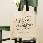 Bolsa Tote Dourado Script Moderno Bem-vindo ao nosso Favor do<br><div class="desc">Esta mochila moderna com uma escrita casual minimalista caligrafia design a ler BEM-VINDO AO NOSSO CASAMENTO, assim como os seus nomes personalizados e a data dos nupciais apresentam linhas limpas para criar uma aparência elegante e sofisticada. O estilo subestimado com o pequeno detalhe do coração de ouro impresso adiciona um...</div>