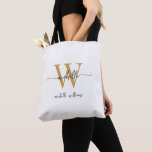 Bolsa Tote Elegante Ouro Branco Feminino Personalizado Monogr<br><div class="desc">Bolsa de mão com monograma inicial do nome personalizado, elegante, moderno, branco e dourado, com letra manuscrita. Este design apresenta seu primeiro nome em uma linda tipografia de letra manuscrita com cauda ornamentada (ou caligrafia) com monograma inicial e sobrenome ou nome completo em dourado e preto sobre fundo branco. Ótimo...</div>