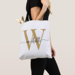 Bolsa Tote Elegante Ouro Branco Feminino Personalizado Monogr<br><div class="desc">Saco de mão personalizado feminino moderno simples e elegante em branco e dourado com monograma inicial do nome personalizado. Este design apresenta seu primeiro nome em uma linda tipografia de letra manuscrita com cauda swash (ou caligrafia) com monograma inicial em dourado e preto sobre fundo branco. Ótimo presente feminino para...</div>