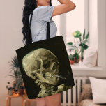 Bolsa Tote Esqueleto com Cigarro queimado | Vincent van Gogh<br><div class="desc">O crânio de um esqueleto com o cigarro queimado (1886) de Vincent van Gogh é uma pintura impressionante e não convencional de vida estática que apresenta um crânio humano com um cigarro aceso entre os dentes. O fundo escuro melhora a escuridão da figura esquelética, enquanto a pequena pluma de fumaça...</div>