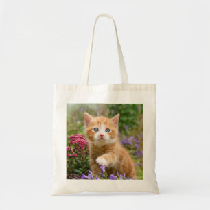 Bolsa Tote Gato de gengibre bonito em um jardim brincando com