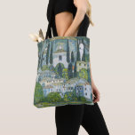 Bolsa Tote Igreja (Kirche) em Cassone por Gustav Klimt<br><div class="desc">Igreja em Cassone - Paisagem com Cyprestes (também conhecida por Kirche em Cassone - Landschaft mit Zypressen) (1913) por Gustav Klimt é uma pintura de arte simbolista da era vitoriana, simbolismo, que apresenta uma igreja na cidade de Cassone com edifícios de pedra e ciprestes à beira do lago Garda, em...</div>