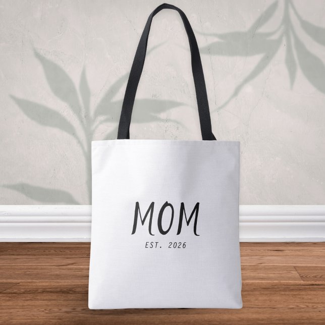 Bolsa Tote Mãe Estabeleceu Novo Presente de Mãe (A stylish tote bag with customizable "Mom Est. 2026" caption in black text on a white background)