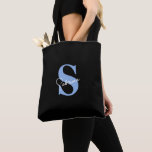 Bolsa Tote Monograma Azul Minimalista Moderno Personalizado<br><div class="desc">Esta bolsa preta moderna, elegante e minimalista é o acessório personalizado perfeito para noivas e damas de honra. Com um monograma suave em azul cornflower com a inicial do primeiro nome e o primeiro nome em letra cursiva branca, combina sofisticação e praticidade, ideal para os essenciais do dia do casamento...</div>