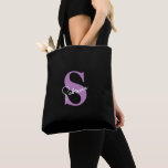 Bolsa Tote Monograma de Lavanda Minimalista Moderna Personali<br><div class="desc">Esta bolsa preta moderna, elegante e minimalista é o acessório personalizado perfeito para noivas e damas de honra. Com um monograma suave em lavanda com a inicial do primeiro nome e o primeiro nome em letra cursiva branca, combina sofisticação e praticidade, ideal para os essenciais do dia do casamento ou...</div>