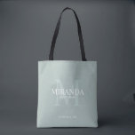 Bolsa Tote Monograma e nome da Bridesmaid Personalizada<br><div class="desc">Adicione um toque pessoal ao seu casamento com o monograma personalizado da dama de honra e o presente de nome. Este design apresenta o nome da dama de honra personalizada com título e data de casamento em branco e monograma em verde-sábio como fundo, no estilo clássico de fonte serif, em...</div>