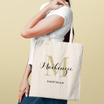 Bolsa Tote Nome de Bridesmaid do Casamento Personalizado Pret<br><div class="desc">O elogioso saco personalizado de tote de casamento apresenta um design de tipografia monograma personalizado com o nome do script de caligrafia moderno e o monograma serif em cores ricas de ouro e preto. Inclui texto personalizado para um título de partido de noiva,  como "BRIDESMAID" ou outro texto preferido.</div>