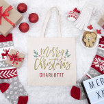 Bolsa Tote Nome Personalizado de Feliz Natal para Script Dour<br><div class="desc">Na moda Merry Christmas tote bag design apresenta ramos verdes festivos de folhas sagradas e frutos vermelhos sotaque o antigo roteiro de ouro moderno design. O texto do monograma personalizado pode ser personalizado com um nome ou outro texto.</div>