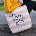 Bolsa Tote Pastel rosa e White Stripes Blue Team Brid<br><div class="desc">Saco Tote All-Over-Impressão com as palavras "Team Bride" em um script de tendência azul contra um fundo de padrão de listras branco e rosa pastel. Perfeito para casamentos para madrinhas, madrinhas de casamento e floreiras. Para outras cores e itens correspondentes, consulte aqui https://www.zazzle.com/collections/119250194970828530?rf=238364477188679314 Personalize-o substituindo o texto do marcador de...</div>