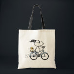 Bolsa Tote Peanuts | Snoopy & Woodstock Bicycle<br><div class="desc">Pedal into style and classic charm with this adorable cream canvas tote bag, featuring Snoopy and Woodstock on a bicycle! This fun tote showcases a delightful line-art illustration of Snoopy, wearing sunglasses, happily riding a vintage-style blue bicycle with Woodstock perched safely behind him. The dashed lines behind the back wheel...</div>