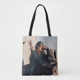 Bolsa Tote Sentada e sorridente vestindo calças pretas