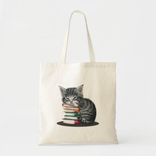 Bolsa Tote Um gatinho sonolento amontoado com uma pilha de li