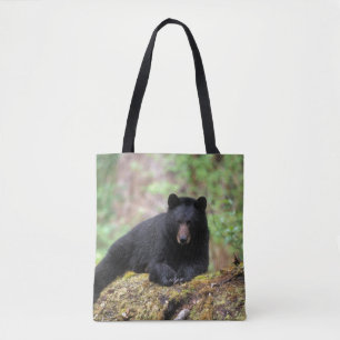 Bolsa Tote Urso preto em um tronco de crescimento antigo na