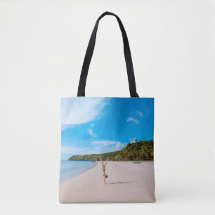 Bolsa Tote Woman doing acrobatic on seashore near mountain ra