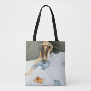 Bolsa Tote Woman sitting on bed holding her hat