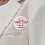 Bóton Redondo 2.54cm Nome de etiqueta cor-de-rosa do arco Bridesmaid<br><div class="desc">Um fundo cor-de-rosa pincelado e suave. Decorado com um arco grande. Personalize e adicione o nome da dama de honra. Script de estilo manuscrito preto.</div>
