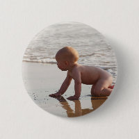 Bebê que joga na areia na praia