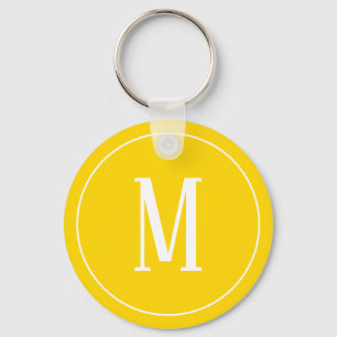 Branco do monograma no chaveiro amarelo dourado